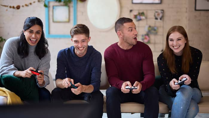 A group of friends is playing a game on a sofa. 